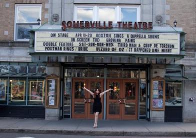 Catherine Argyrople stands in front of the Somerville Theater's marquee which is showcasing her film “Growing Pains,”